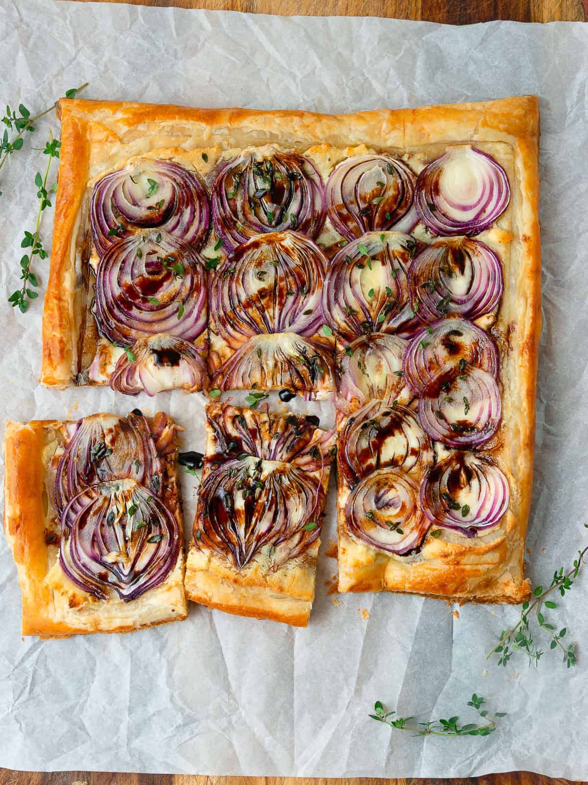 This savory onion tart is layered with boursin cheese, thinly sliced onions, fresh thyme and drizzled with balsamic.