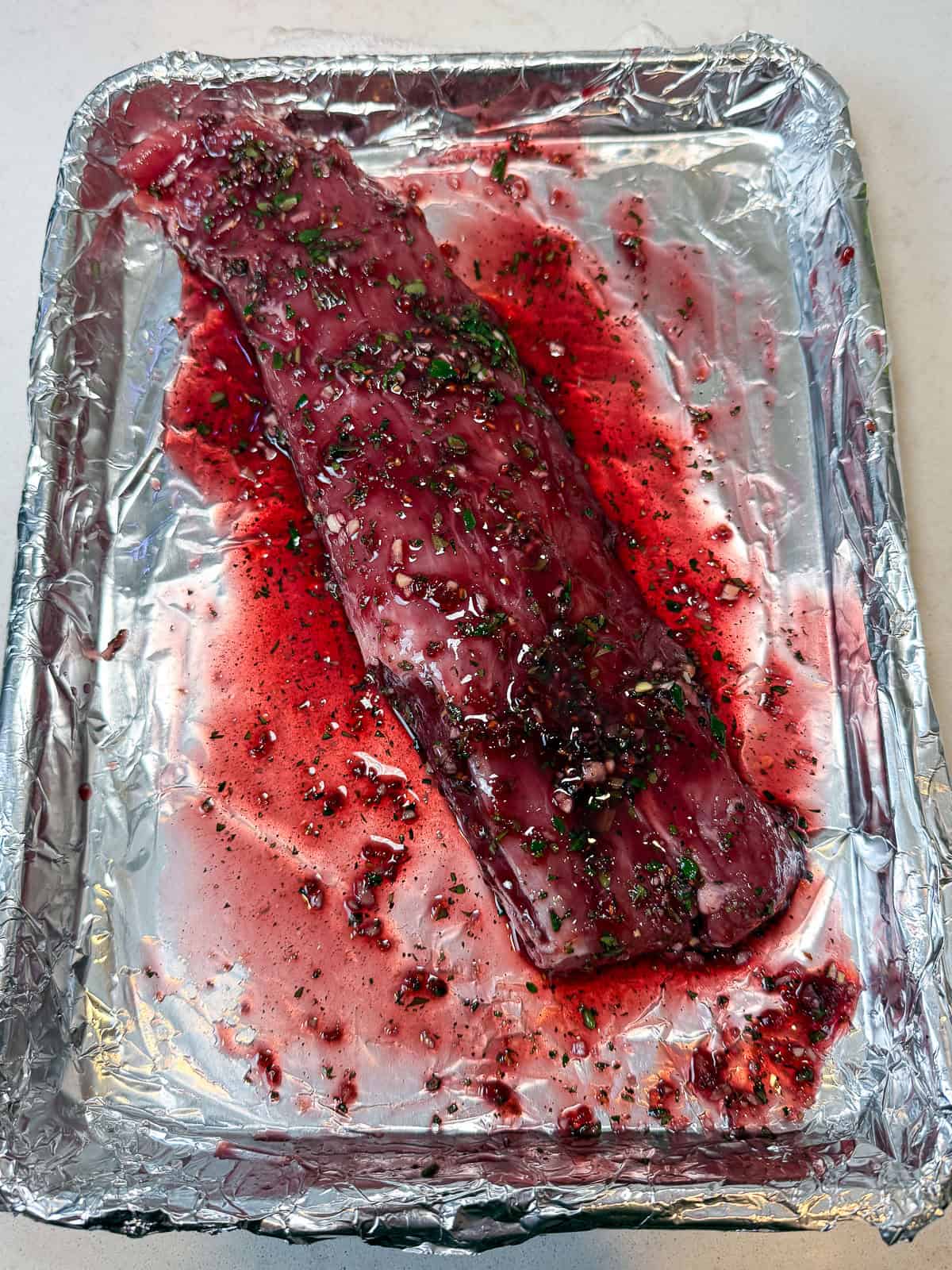 Place the pork loin on a foil lined baking sheet and pour the jam glaze all over the pork loin.