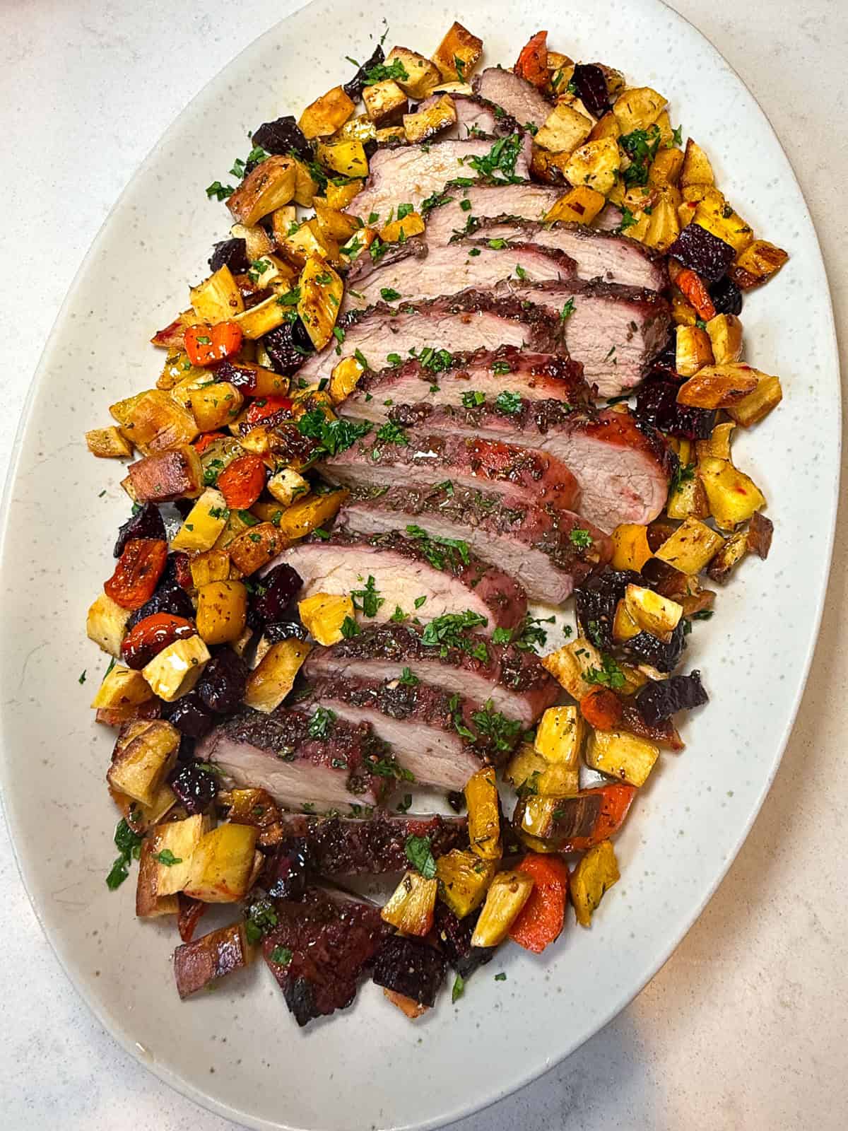 Serve the roasted pork line alongside te roasted root vegetables.
